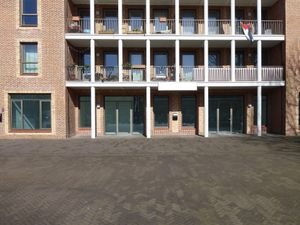 Facade of a modern brick building with balconies in sunny Amsterdam.