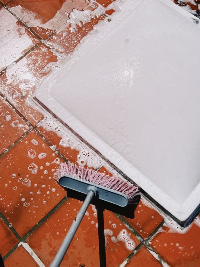 Close-up of soapy tiles being scrubbed. Perfect for cleaning and maintenance themes.